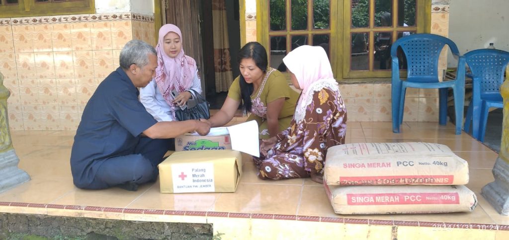 Gigih Priambodo, A.Md Sub Bidang Penanggulangan bencana dan SDM Markas PMI Kabupaten Jember saat menyerahkan bantuan pada korban
